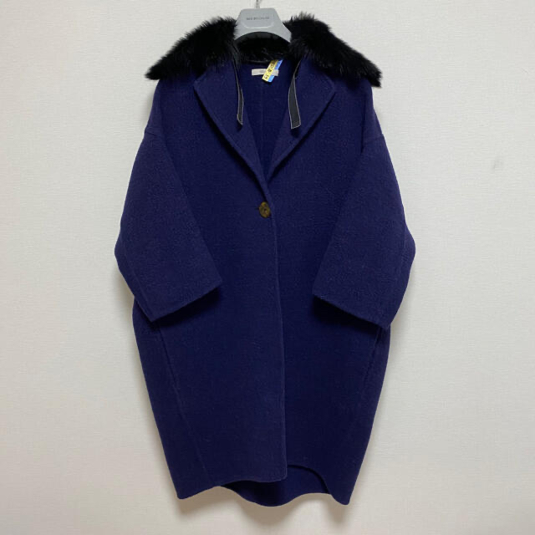 Navy CELINE fur-trimmed cocoon coat on a hanger against a plain wall.