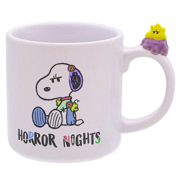White ceramic mug showing a cartoon dog illustration with the text “HORROR NIGHTS” and a small yellow figure attached to the handle.