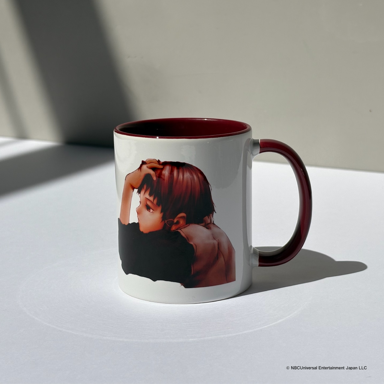 Ceramic mug with a red interior and handle showing artwork from 「円環帰点」 for 安倍吉俊 画業30周年記念展.