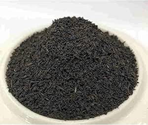 A white dish filled with loose Ceylon black tea leaves.