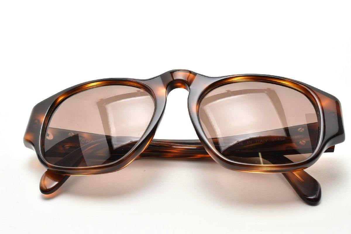 Folded tortoiseshell plastic sunglasses with brown-tinted lenses shown on a white background.