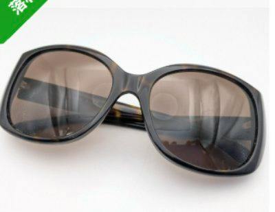 Plastic CHANEL sunglasses with tortoiseshell frame and brown-tinted lenses shown on a white background.