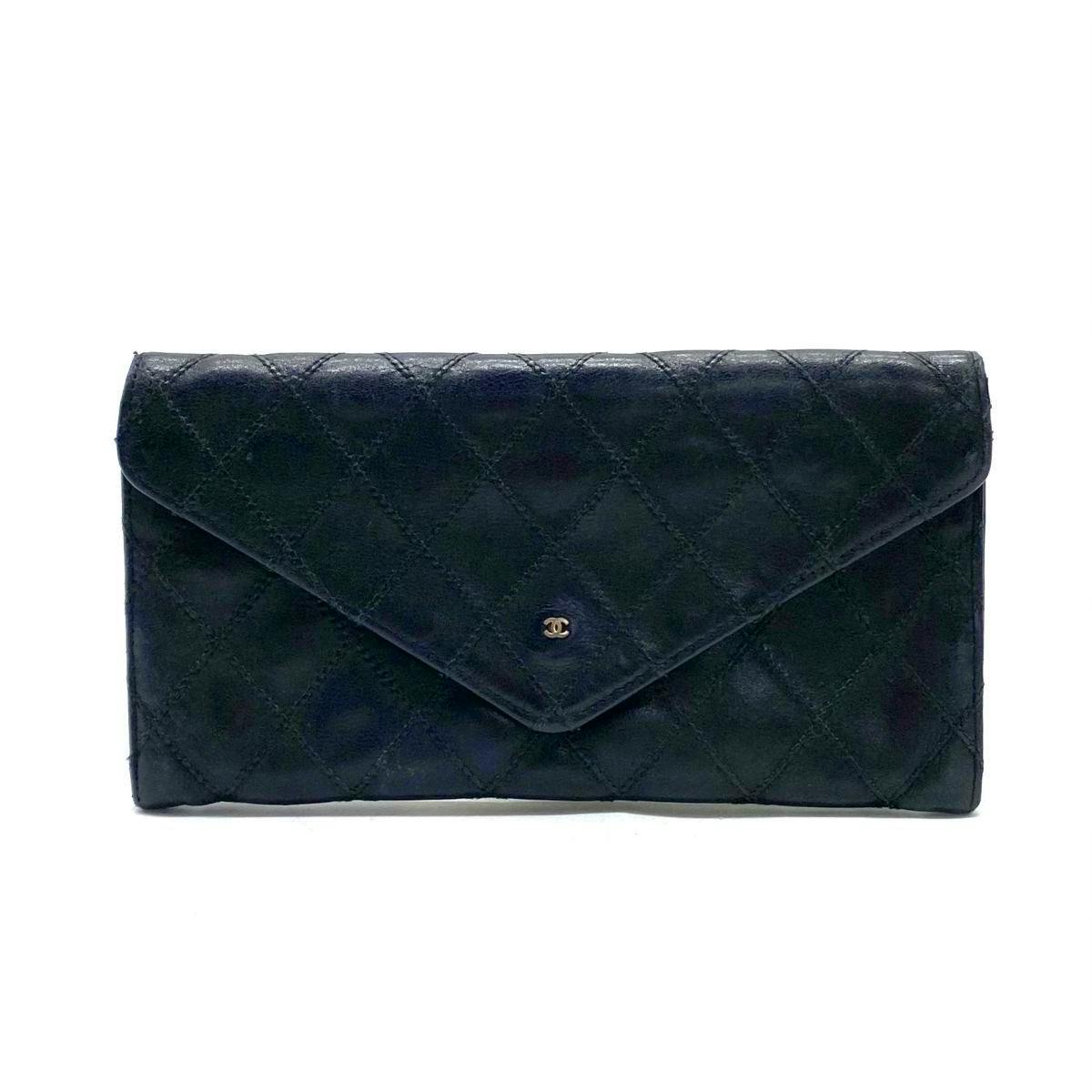 Front view of a black quilted CHANEL leather bi-fold wallet with envelope flap and small metal CC logo.