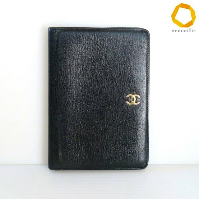 Front view of a black CHANEL bi-fold cow leather wallet with a small gold CC logo on the front.