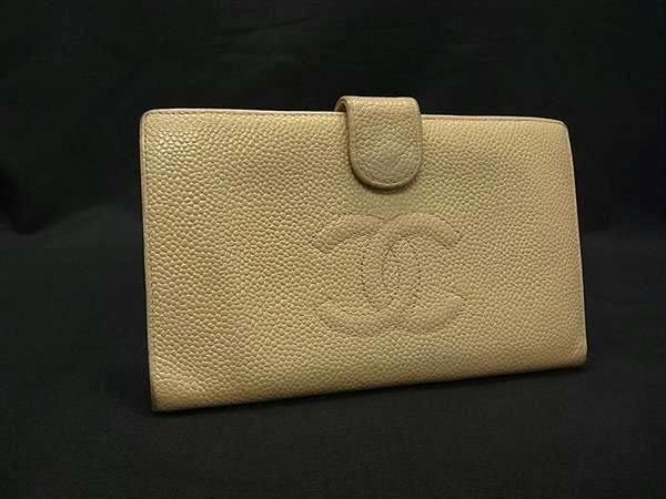 Front view of a beige CHANEL caviar leather bi-fold long wallet with embossed interlocking CC logo and a snap-tab closure.