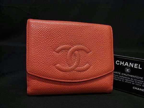Front view of the pink CHANEL caviar leather bi-fold wallet with an embossed CC logo shown on a black background next to an authenticity card.