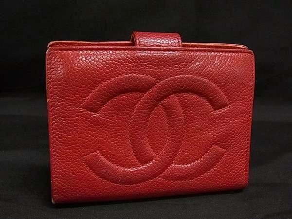 Red CHANEL caviar leather bi-fold wallet with a large embossed interlocking CC logo on the front.