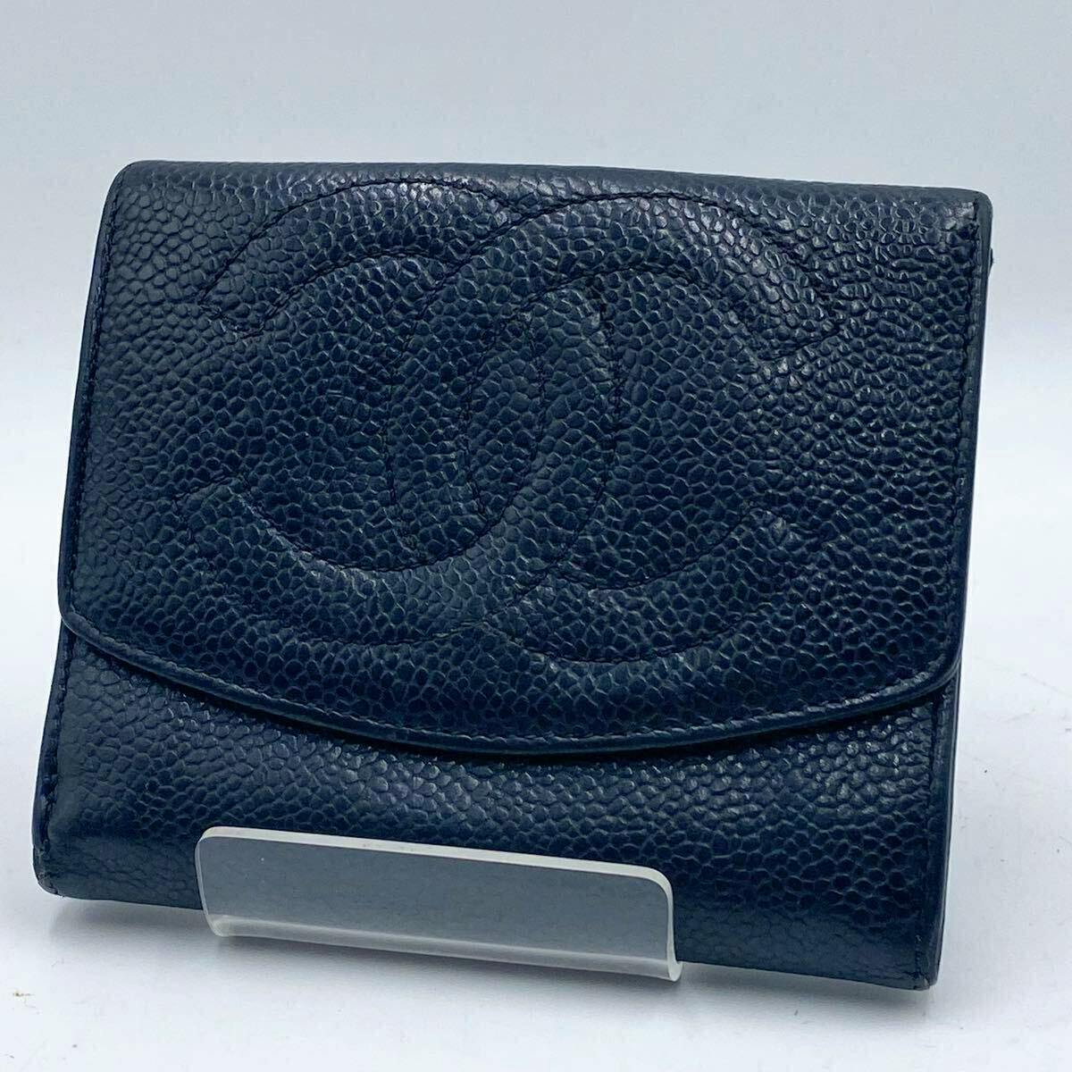 Front view of the CHANEL caviar (pebbled) cow leather tri-fold wallet showing the embossed CC logo on the flap.