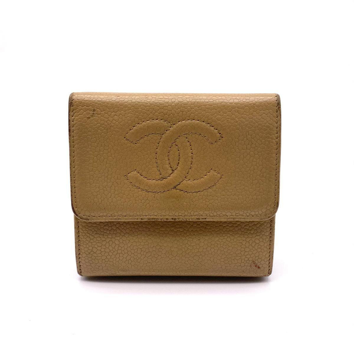 Front view of a beige CHANEL caviar cow leather trifold wallet with an embossed interlocking CC logo.