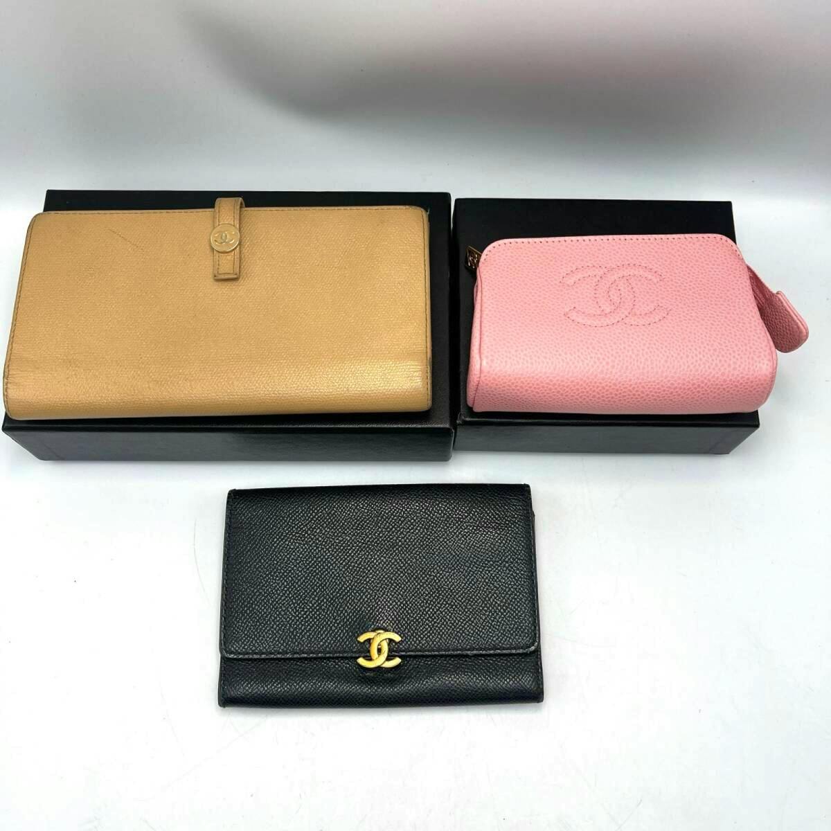 Three CHANEL leather items on a white background: a tan long wallet, a pink pouch, and a black folding wallet with a CC logo.