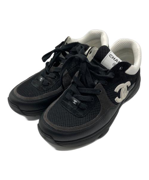 Pair of black low-cut sneakers with a mesh upper, white padded collar, and interlocking Coco mark logo on the side on a white background.