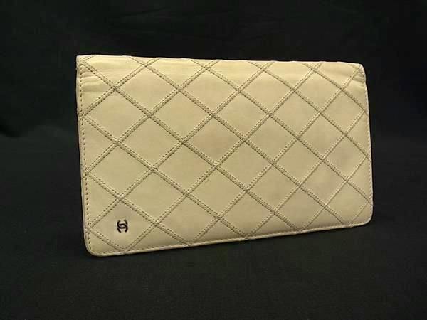 Ivory quilted CHANEL long bi-fold wallet exterior with a small CC logo, shown on a black background.