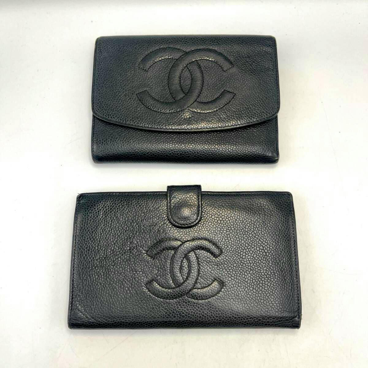 Two black CHANEL folding wallets in caviar leather showing embossed interlocking CC logos on a white background.