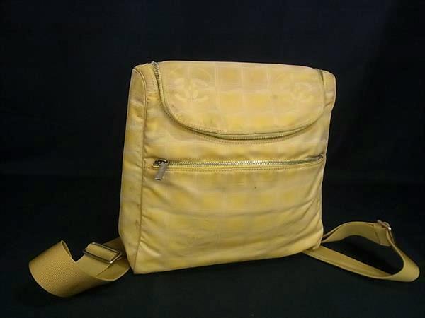 Yellow Chanel nylon backpack shown front view on a black background.
