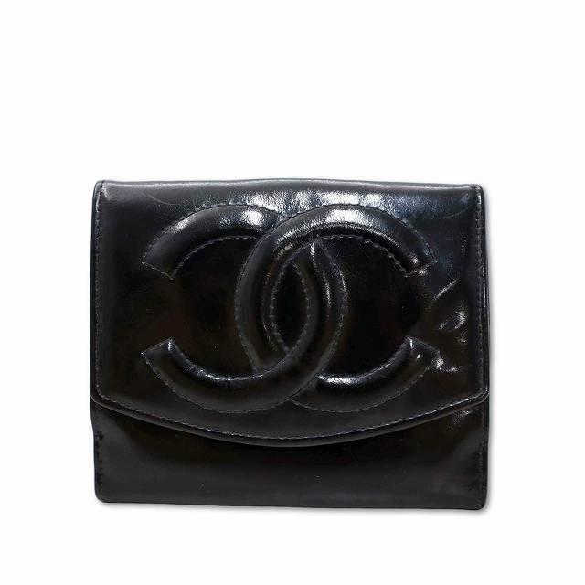 Front view of a black CHANEL compact bi-fold wallet showing a raised interlocking CC logo on the flap.
