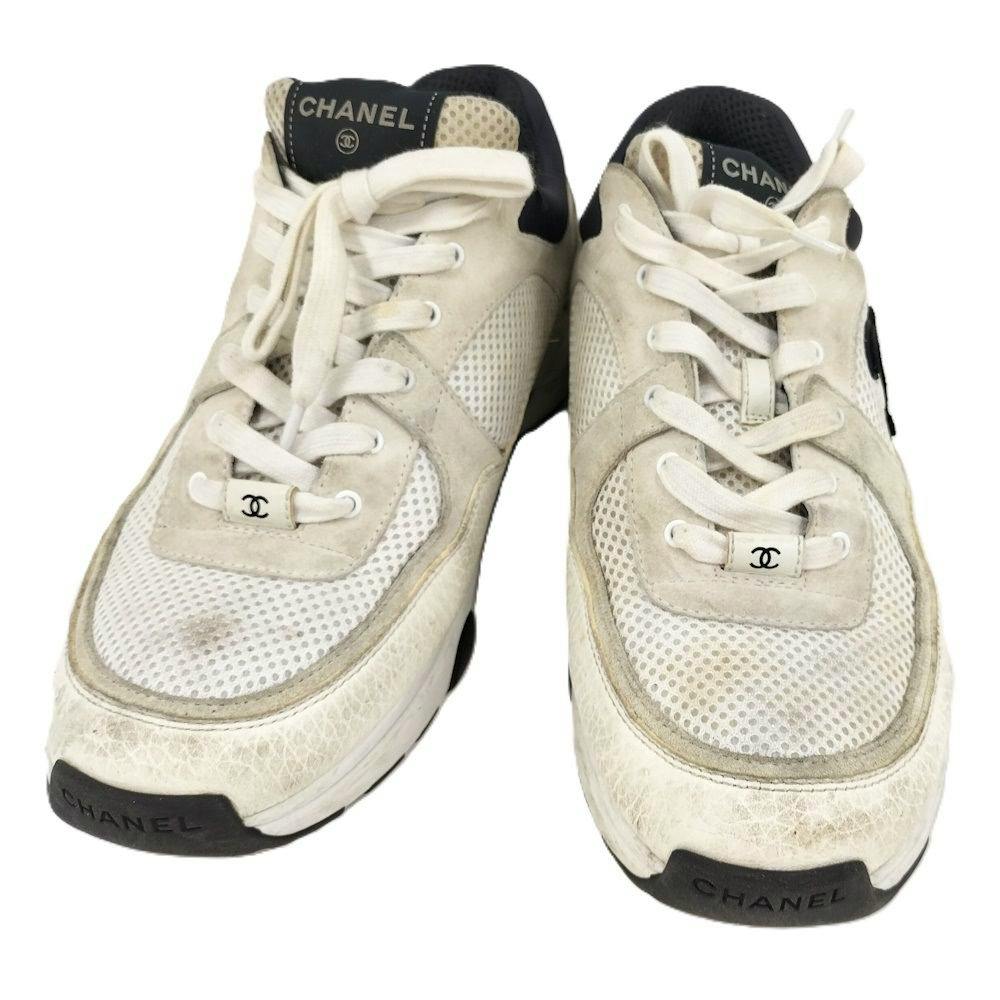 Front view of a pair of white CHANEL Coco Mark sneakers shown on a white background.
