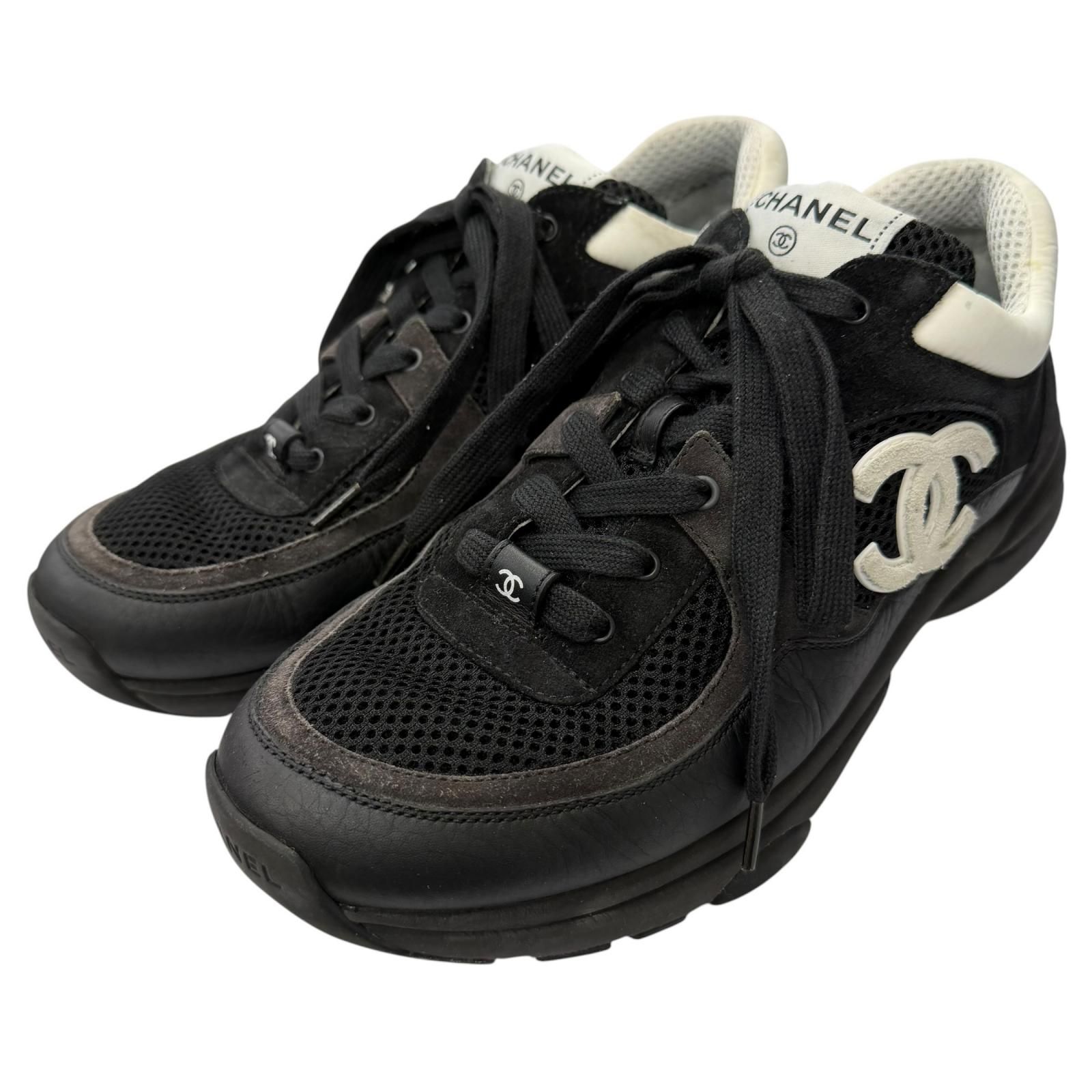 Black Chanel low-cut lace-up sneakers with visible interlocking CC logo.