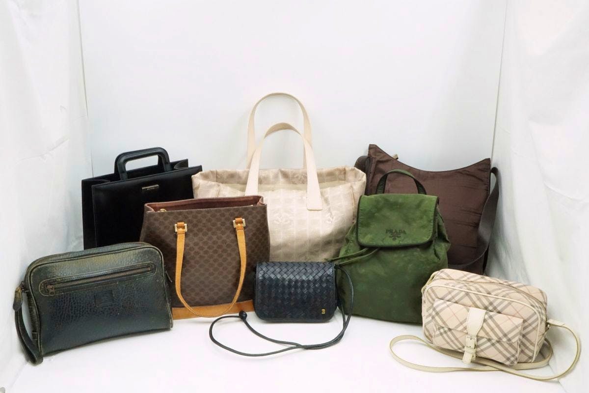 Eight assorted tote, shoulder, and handheld bags arranged together against a white backdrop.