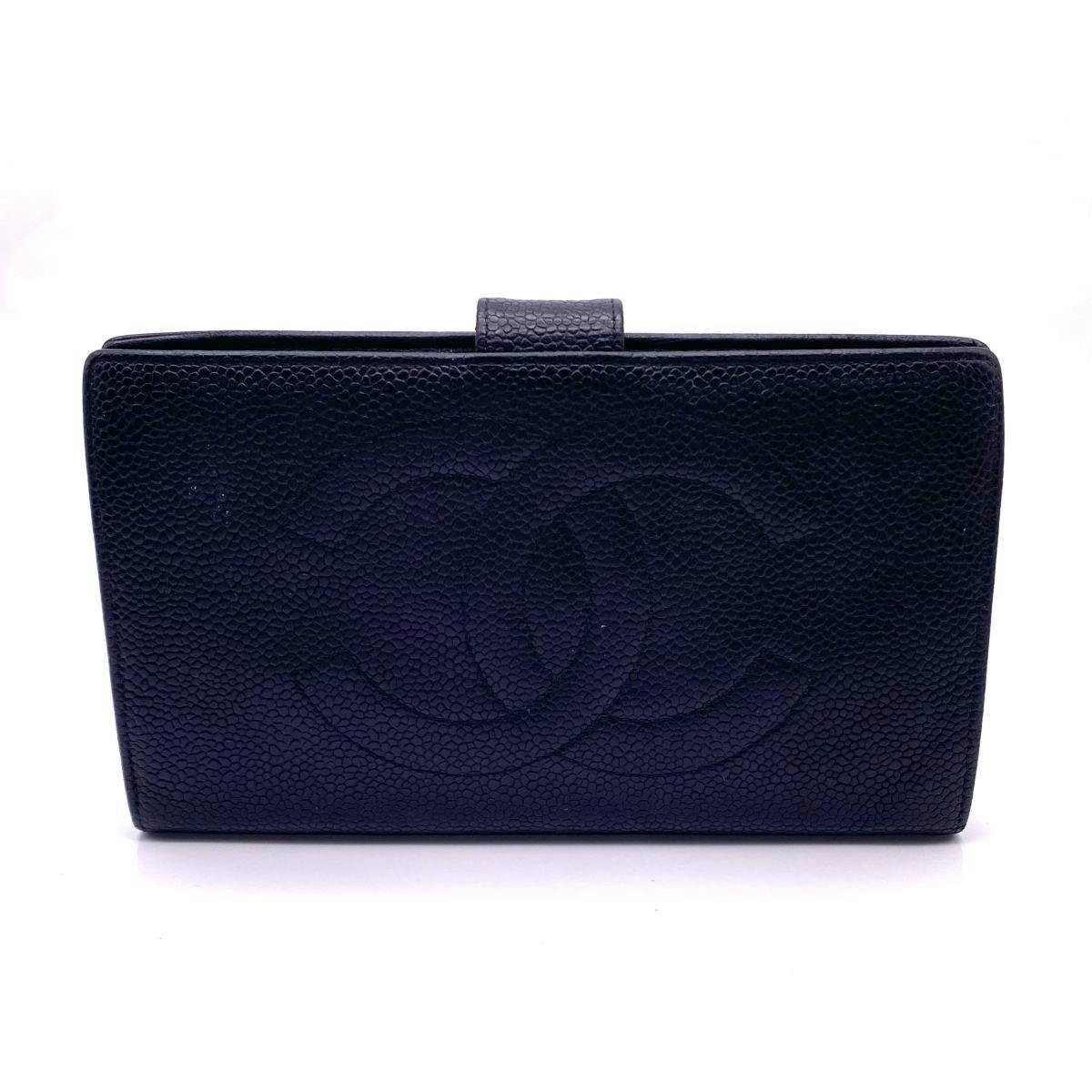 Front exterior of the black Chanel caviar leather bi-fold long wallet showing a large embossed CC logo and a tab closure.