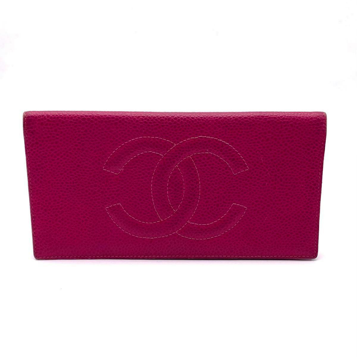 Front exterior of a magenta CHANEL caviar-skin bi-fold long wallet with a large stitched interlocking CC logo.