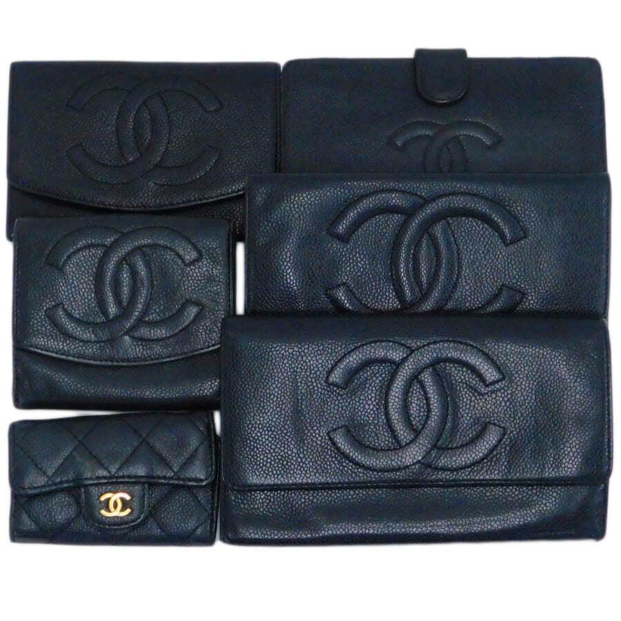 Six black Chanel leather wallets and small goods arranged together showing quilted and CC-embossed designs.