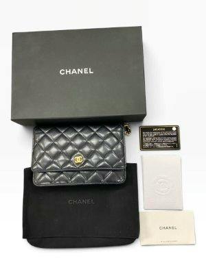 Black CHANEL matelassé lambskin chain wallet with gold hardware displayed with box, dust bag, and authenticity card.