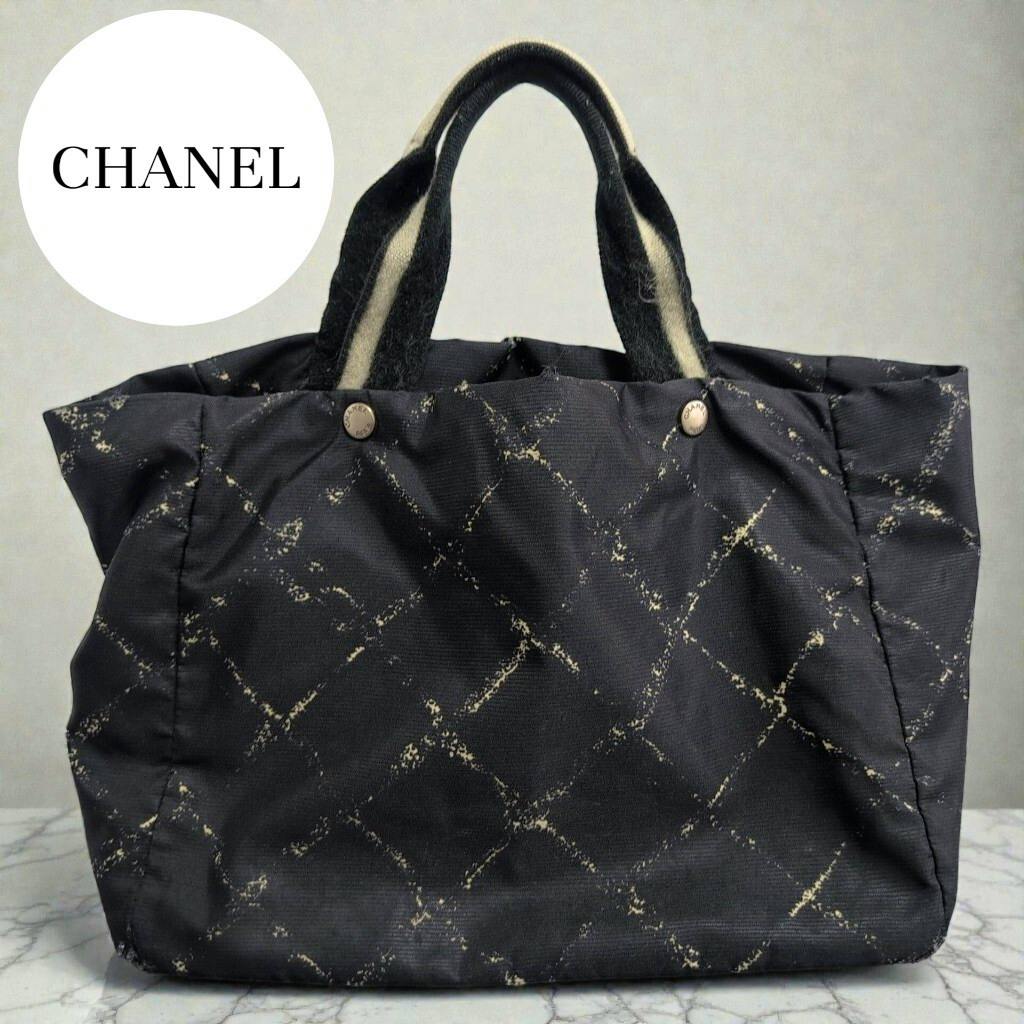 Front view of a black CHANEL nylon check tote bag with short handles.