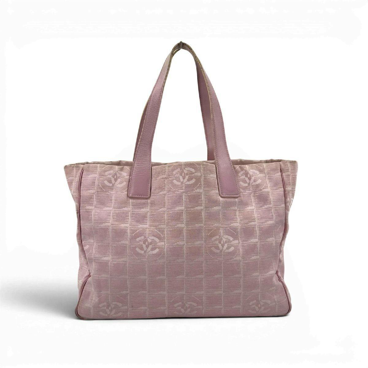 Front view of a pink CHANEL New Travel Line MM shoulder tote bag showing dual top handles and a repeating CC pattern on the fabric.