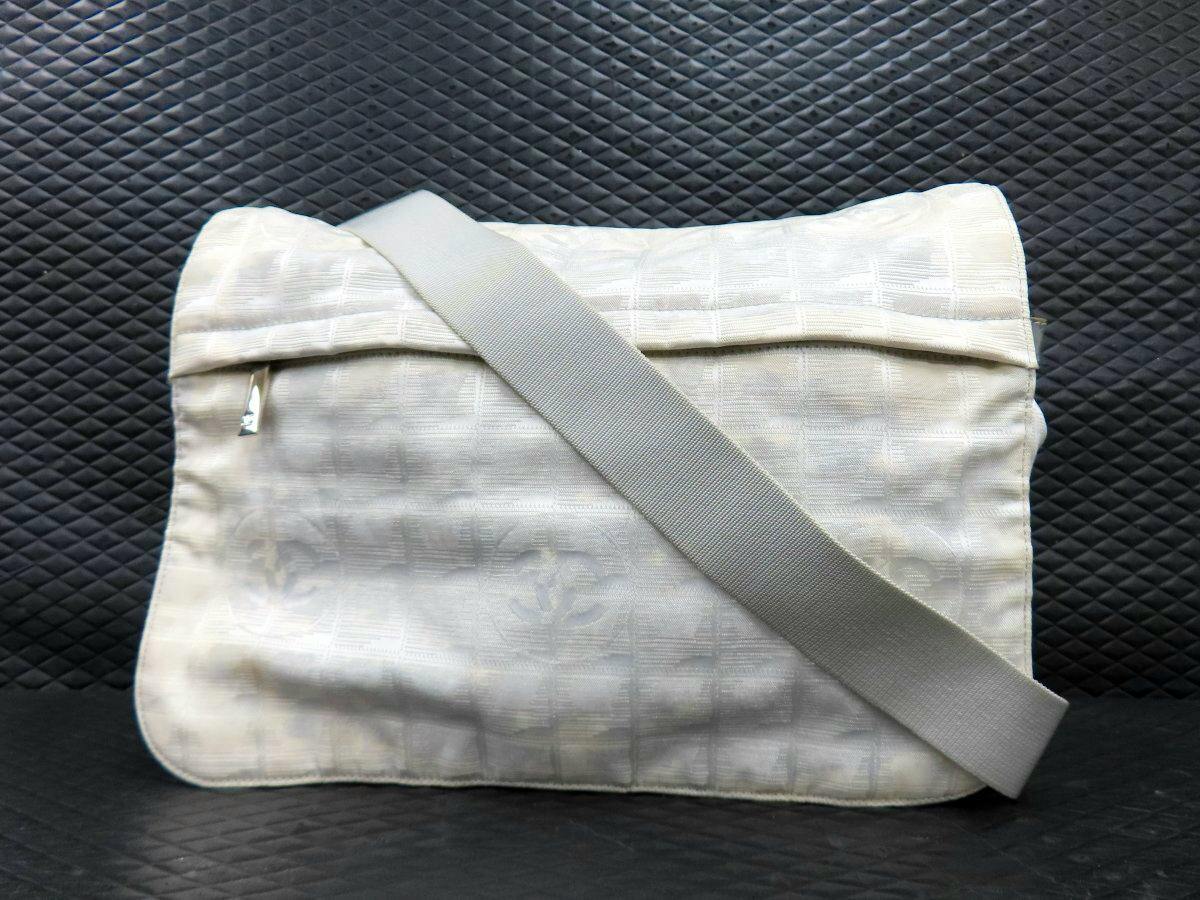 CHANEL nylon shoulder bag shown from the back with a wide fabric shoulder strap across it.