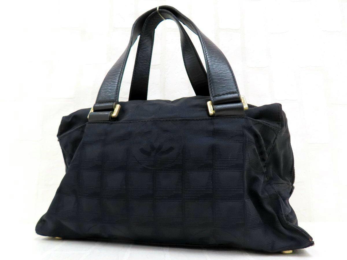 Black CHANEL nylon and calf leather handbag with double top handles and gold hardware shown from the front.
