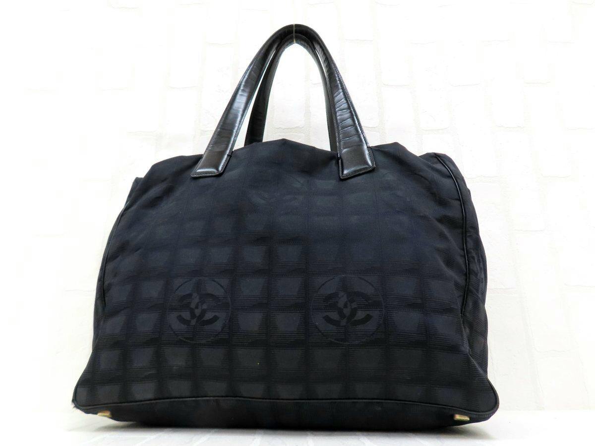 Front view of the black Chanel New Travel Line nylon and calf leather tote bag with top handles and tonal CC logo pattern.