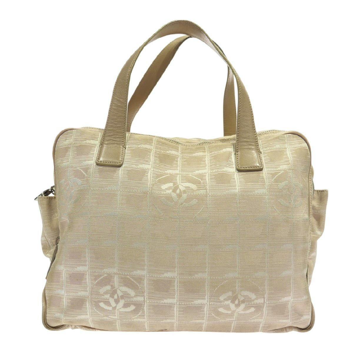 Beige nylon Chanel handbag with short top handles and repeating CC logo pattern on fabric.