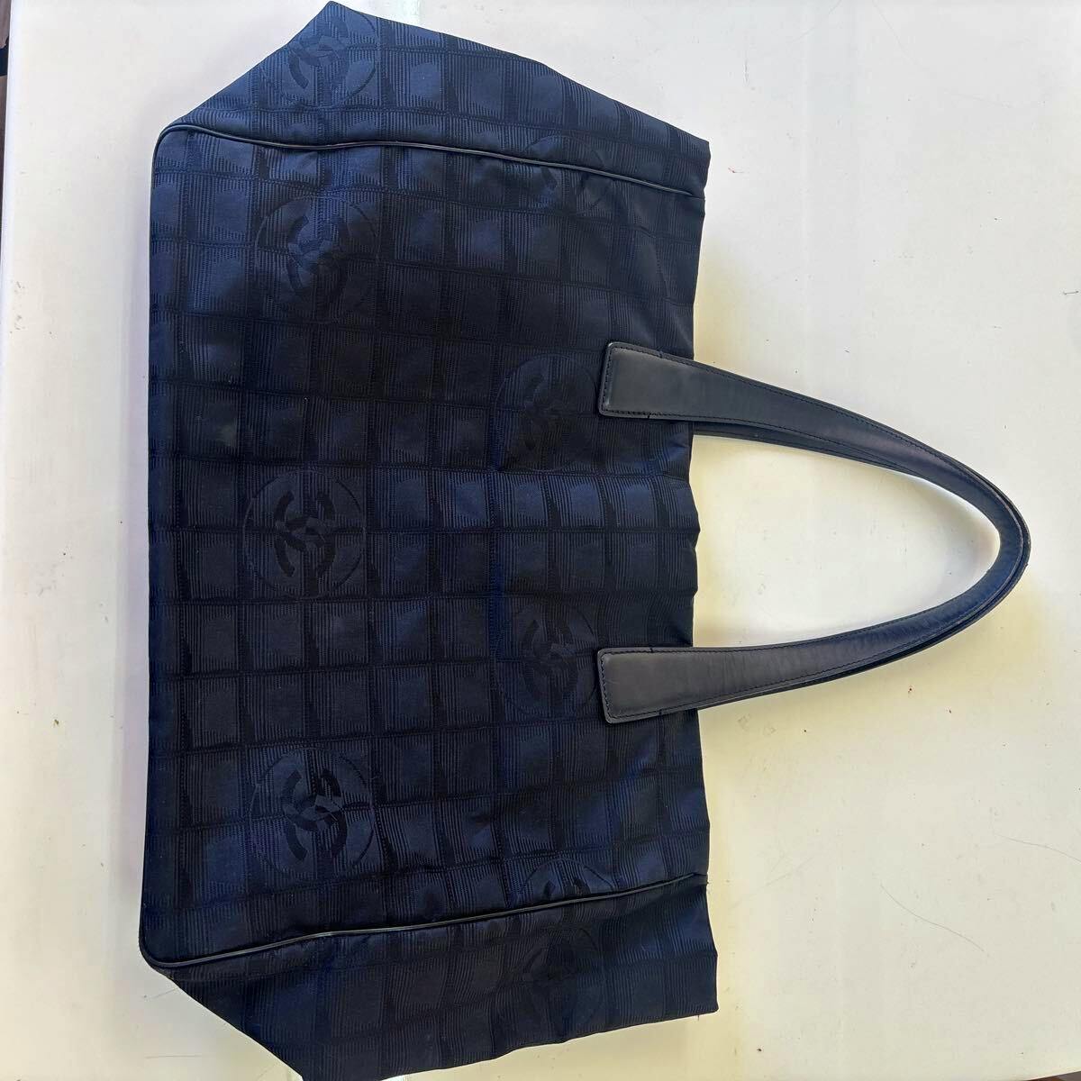 Navy CHANEL New Travel Line nylon jacquard tote bag laid flat showing the exterior pattern and handles.