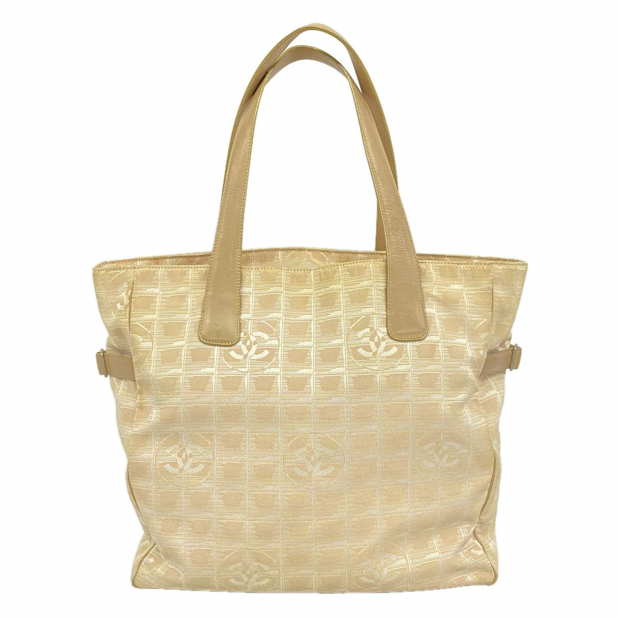 Beige CHANEL nylon tote bag with top handles and repeating CC logo pattern on a white background.