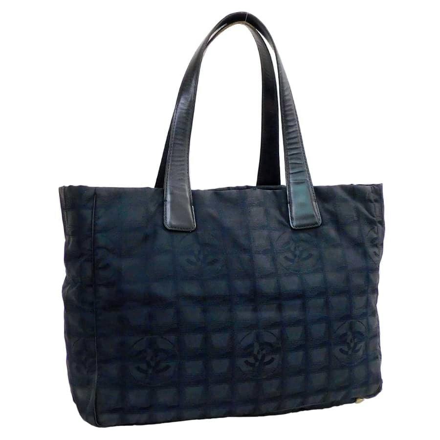 Front view of a black CHANEL nylon jacquard tote bag with twin shoulder straps.