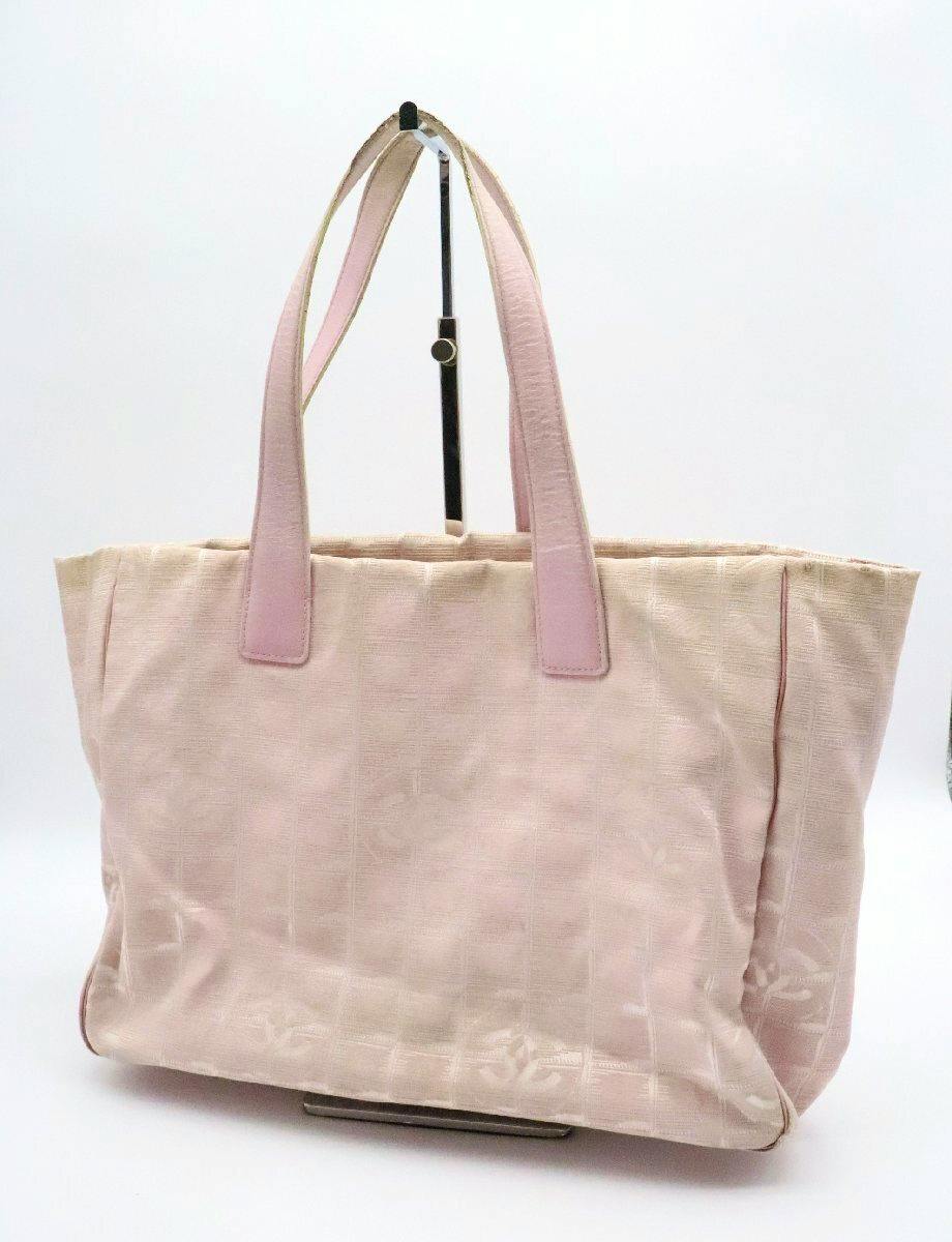 Light pink nylon CHANEL New Travel Line MM tote bag shown front-facing with two pink top handles on a display stand.