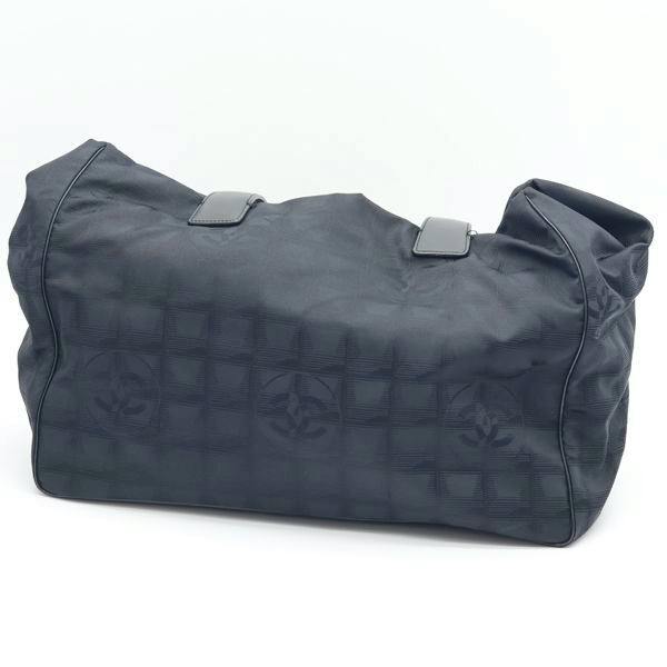 Black Chanel Neutravel canvas tote bag with subtle CC pattern, shown on a white background.