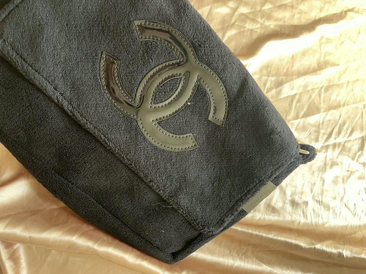 Close-up of the front of the black CHANEL messenger shoulder bag showing the glossy black CC logo on the flap.
