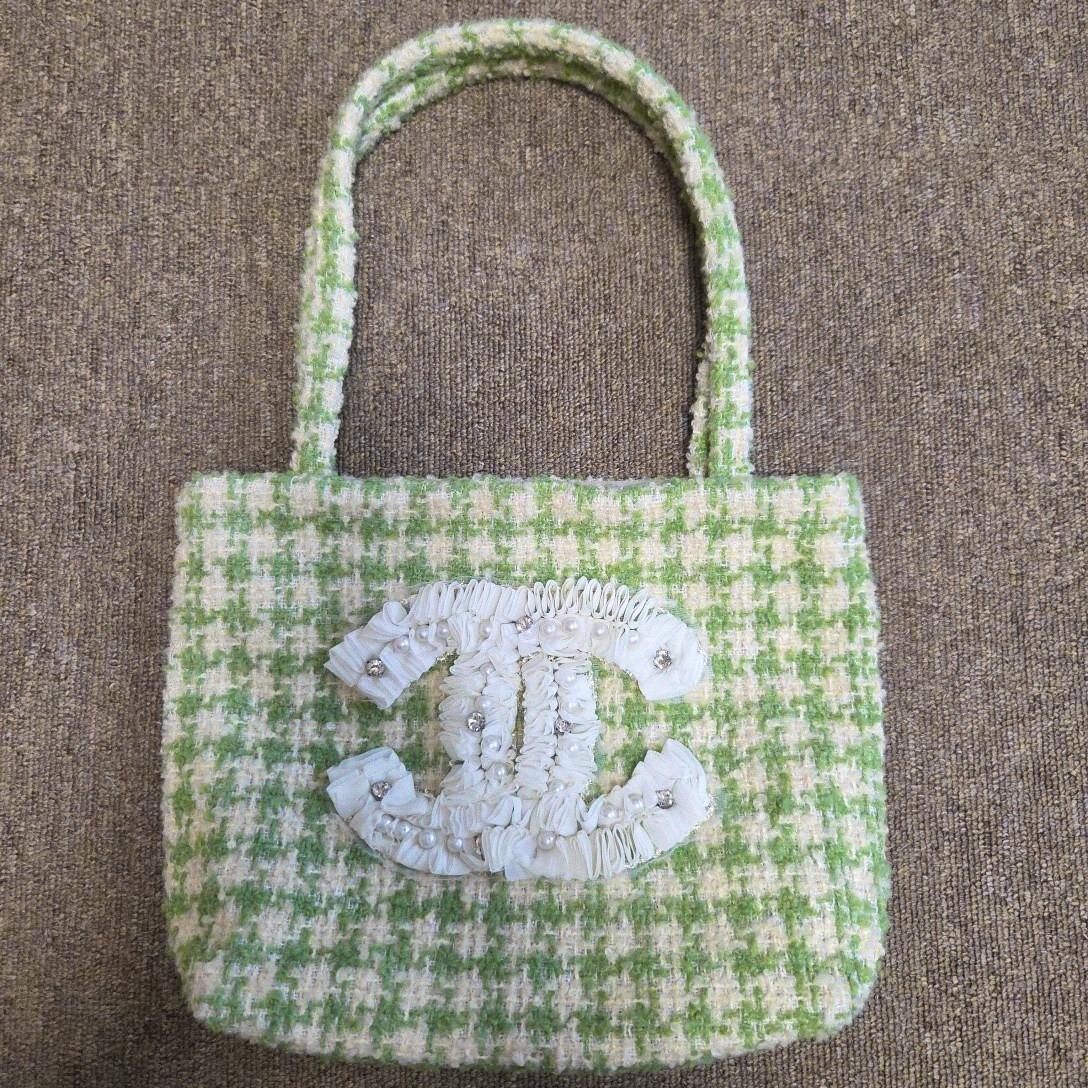 Green and white tweed tote bag with two handles and a white ruffled interlocking CC logo decorated with pearls on the front.