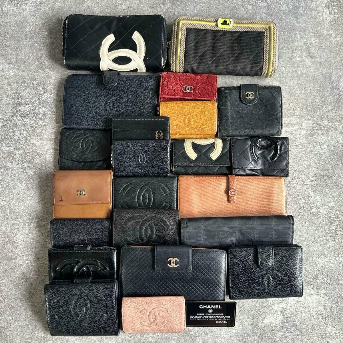 Multiple CHANEL wallets and small leather wallets arranged on a gray surface showing various styles and colors.