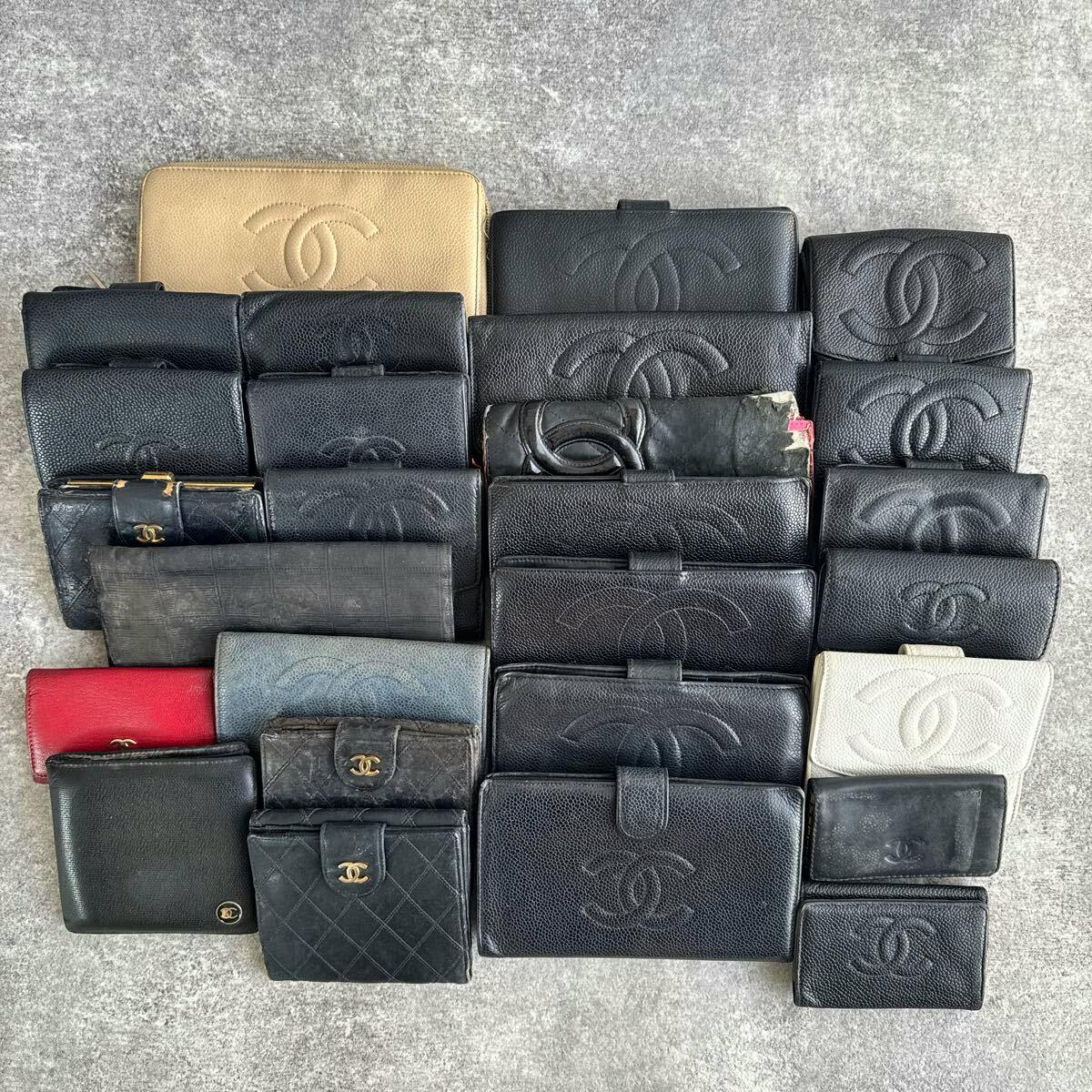 Multiple CHANEL wallets and small leather goods arranged flat on a gray surface.
