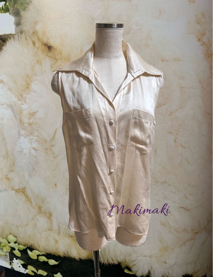 Sleeveless silk women's blouse (CHANEL) displayed on a dress form showing the collar, front button placket, and chest pockets.
