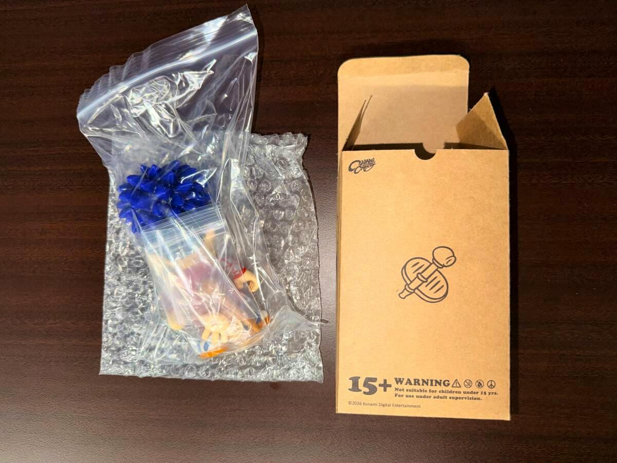 A Chang Chang Toy ゴエモン plastic figure packaged in a clear resealable bag with bubble wrap beside its cardboard box on a dark tabletop.