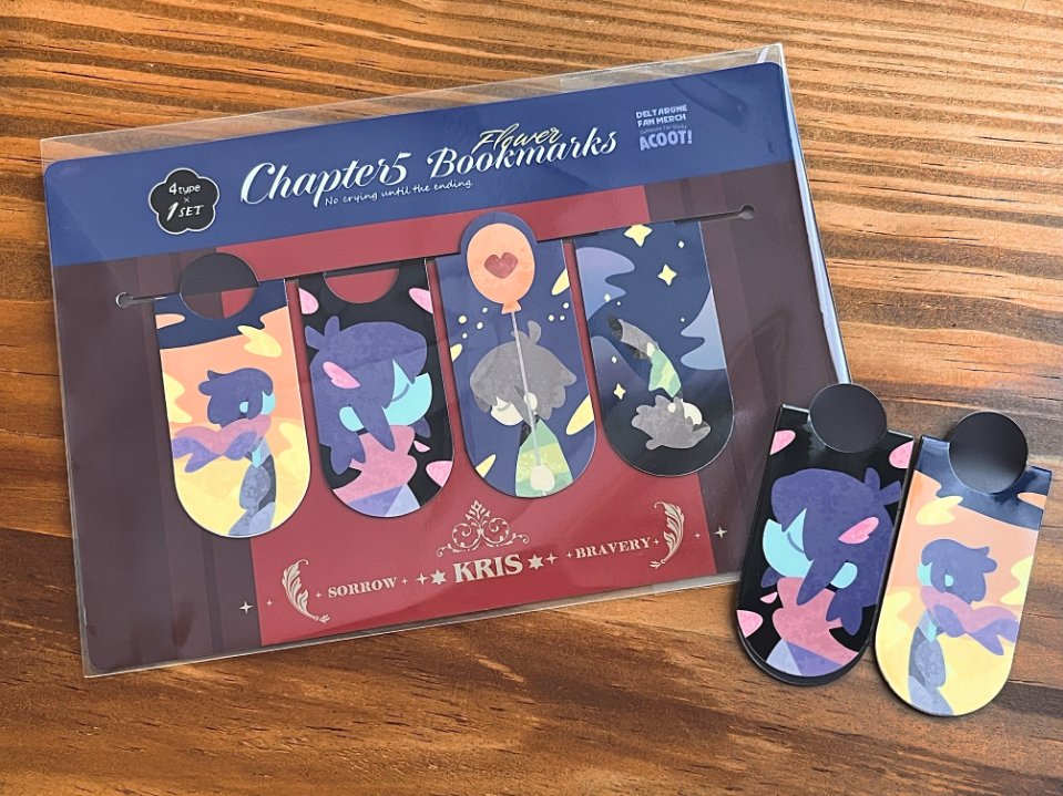 Packaged Chapter5 magnetic bookmark set on a wooden table with two illustrated magnet bookmarks displayed beside it.