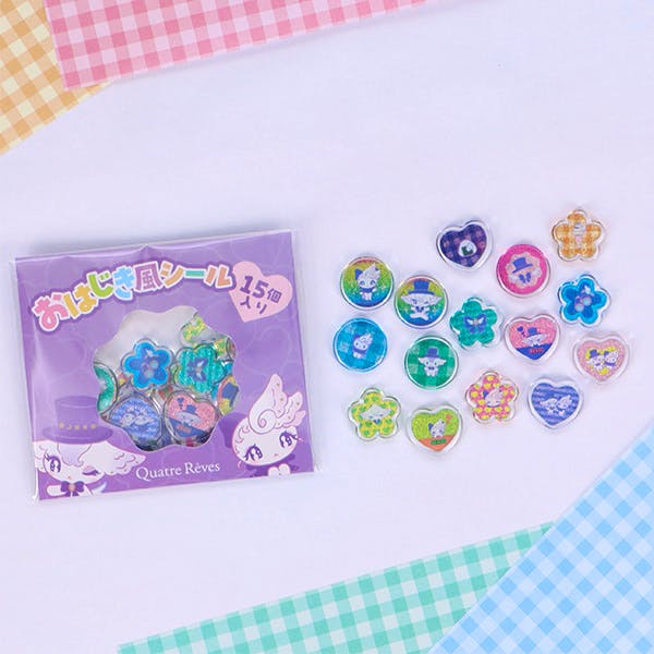 Plastic character stickers in various shapes arranged beside a purple product box.