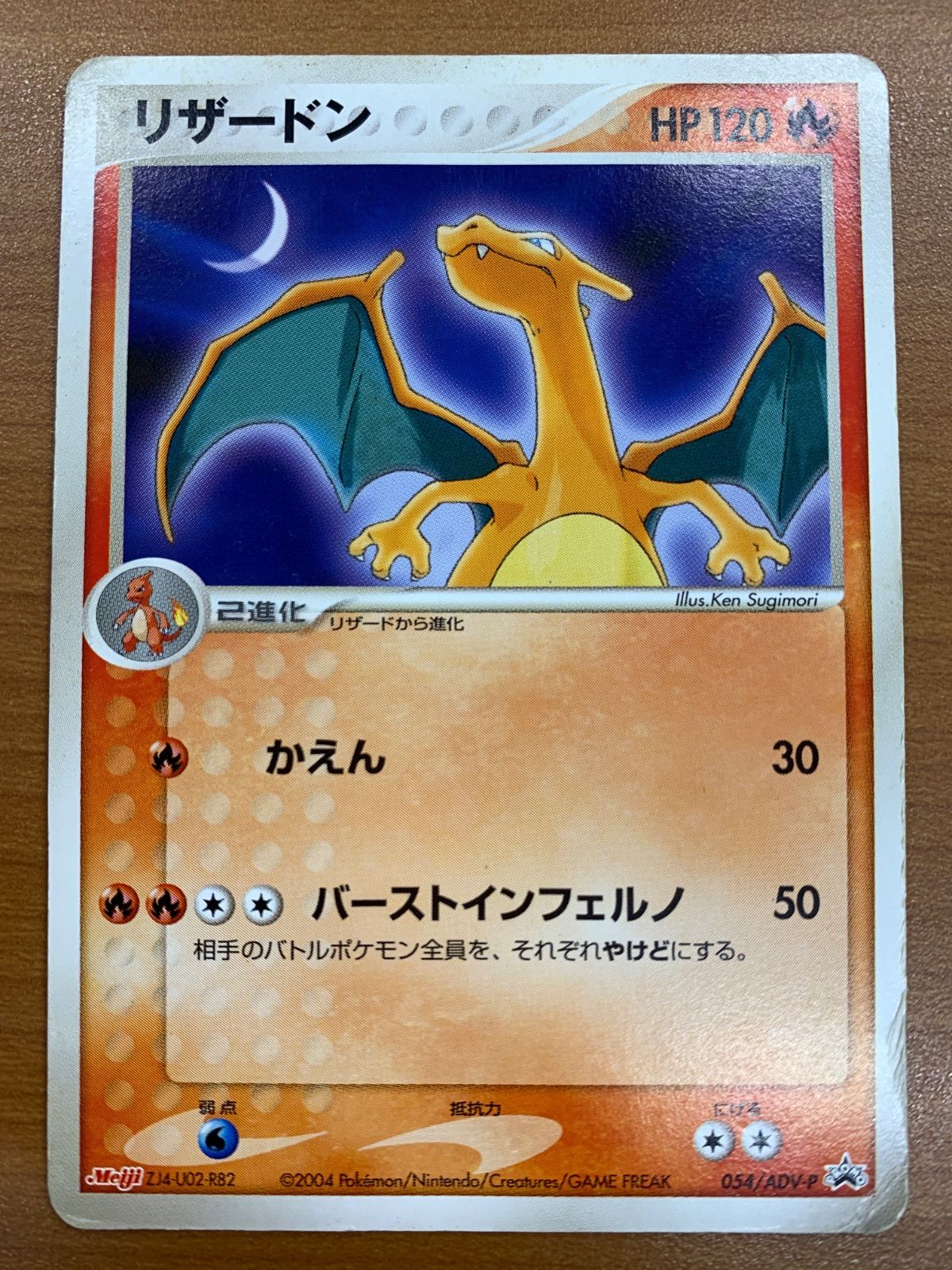 Front photograph of a Japanese リザードン (Charizard) Pokémon trading card showing artwork and Japanese text.