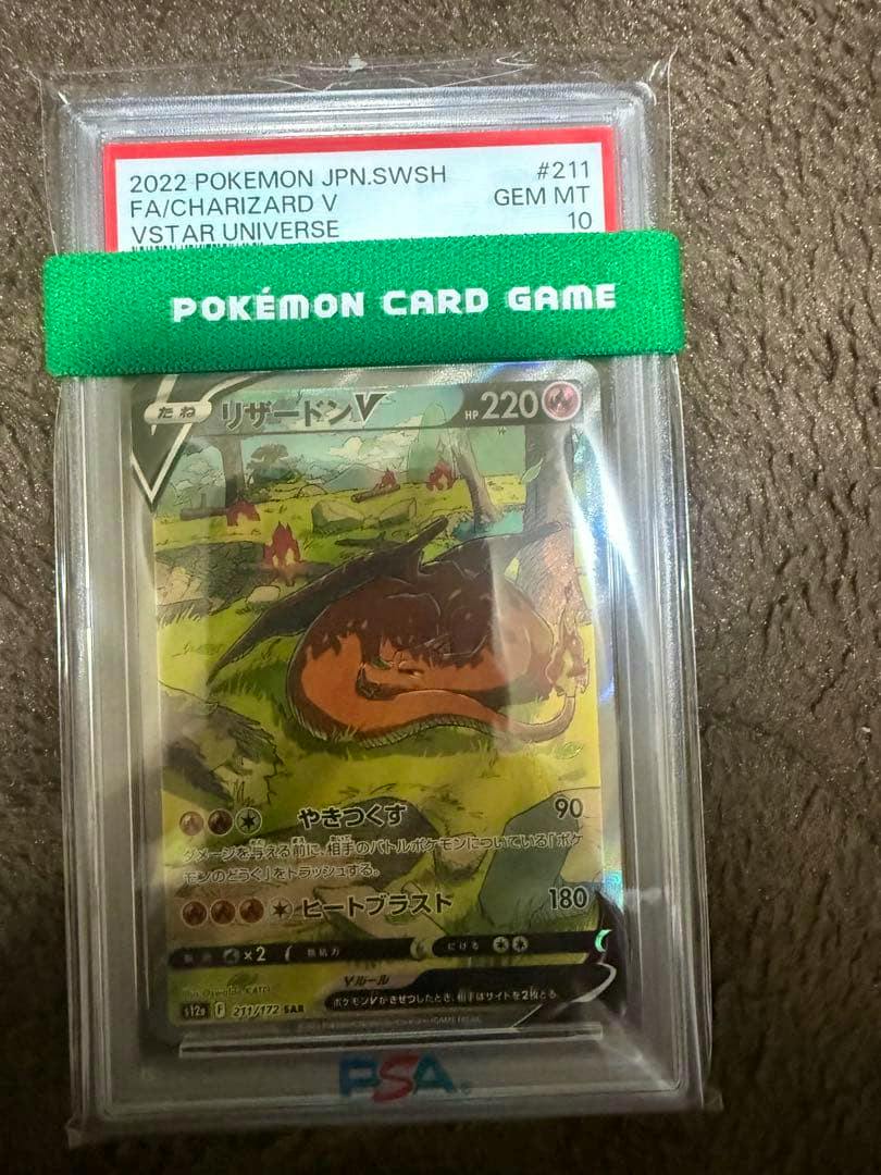 PSA-graded リザードンV (Charizard V) trading card shown front-facing in a protective slab with the PSA label visible.