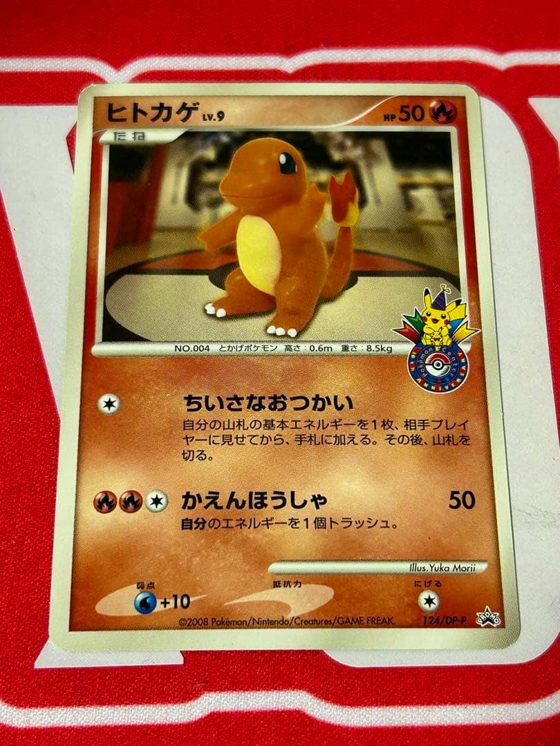 Front of the ヒトカゲ (Charmander) promo trading card 124/DP-P showing the card artwork and Japanese text.