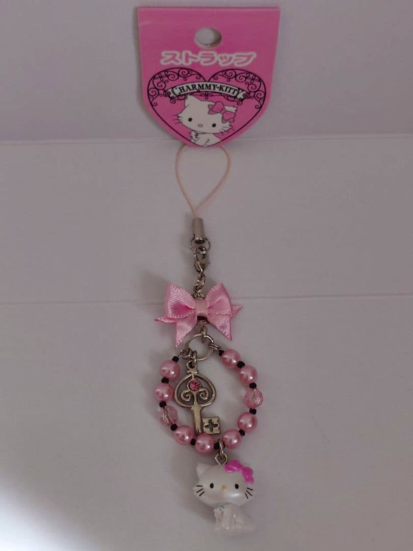 Charmmy Kitty keychain strap with pink beads, a bow, a key-shaped charm, and a small white Kitty figure.