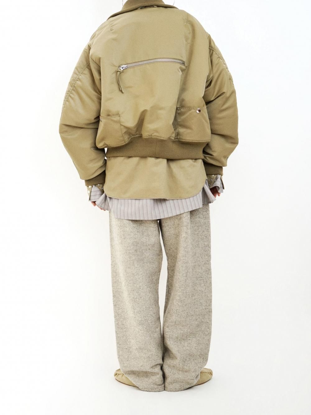 Rear view of a model wearing gray wool pants.